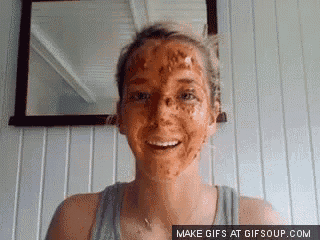 a woman with dirt on her face is smiling in front of a mirror
