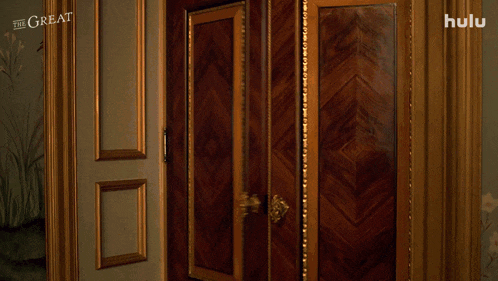 a woman opens a door in a room with the great written on the wall