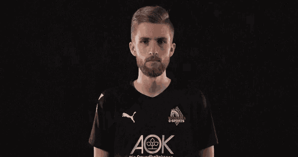 a man wearing a black shirt with the word aok on it