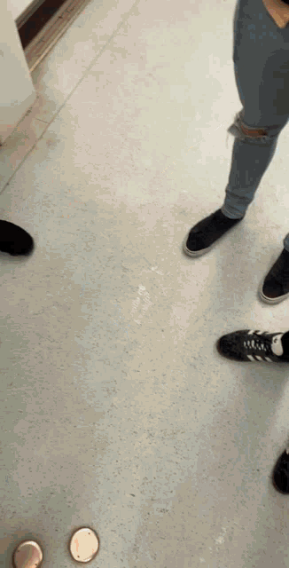 a group of people standing on a white tile floor