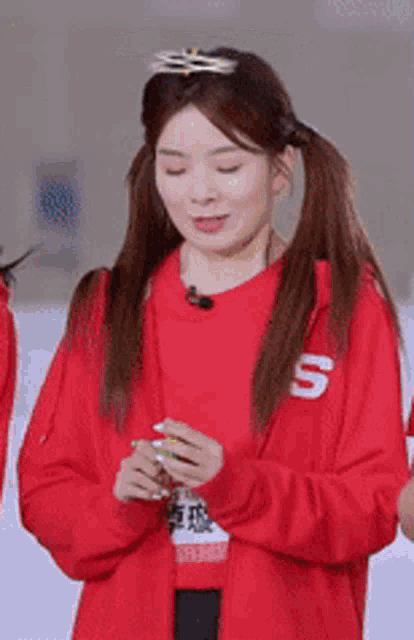 a woman wearing a red sweater with the letter s on it