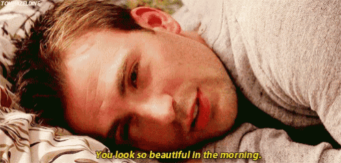 a man is laying on a bed and saying " you look so beautiful in the morning " .
