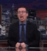 a man in a suit and tie is screaming in front of a screen that says it 's not fair .