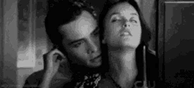 a man and a woman are looking at each other in a mirror .