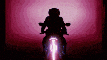a person riding a motorcycle in a dark room