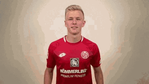 a man wearing a red shirt that says kommerling premium fenstr