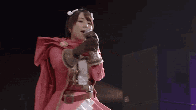 a woman in a red dress is holding a microphone