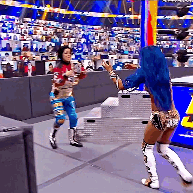 a woman with blue hair is holding a trophy while another woman stands behind her