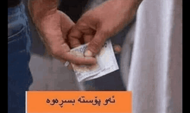 a person is holding a piece of money in their hand and putting it in another person 's pocket .