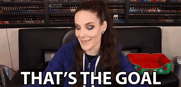 a woman in a blue hoodie is smiling and saying that 's the goal .