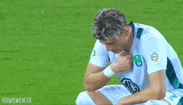 a soccer player with the number 3 on his shirt is kneeling down