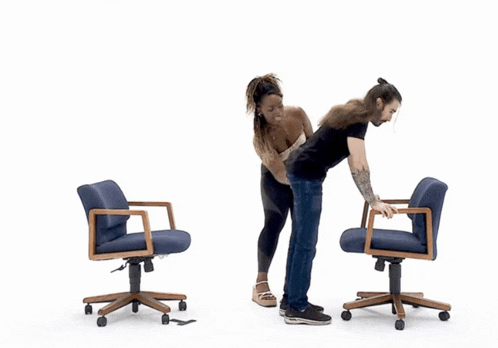 a man and a woman are standing next to each other in front of blue chairs