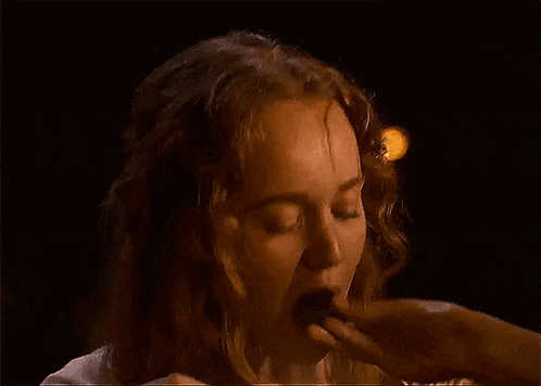 a woman is being kissed by a man in the dark .