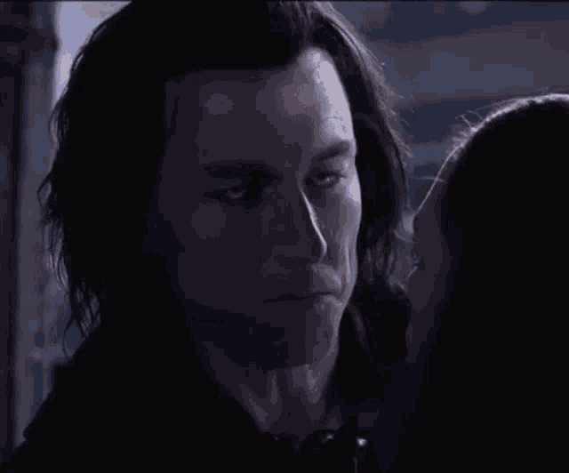 a woman kisses a man on the cheek in a dark room
