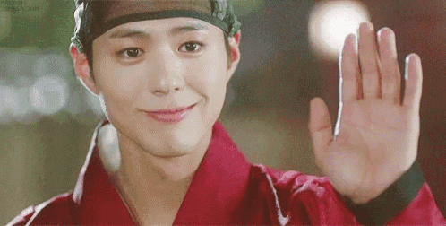 a young man in a traditional costume is waving his hand .