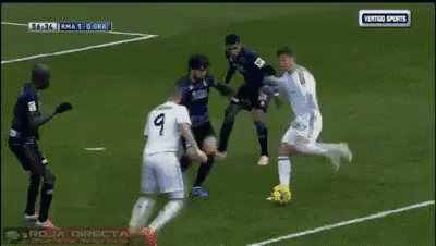 a soccer goalie dives to catch a ball in front of a banner that says " marca solo hay que "
