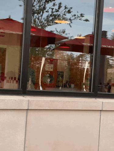 a reflection of a restaurant in a window with a sign that says sell your ear on it