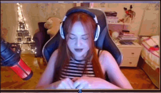 a woman wearing headphones is sitting in front of a microphone in a room .