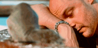 a man is laying down with his head on his wrist .