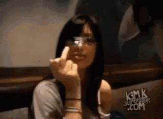 a woman wearing glasses is giving a middle finger .