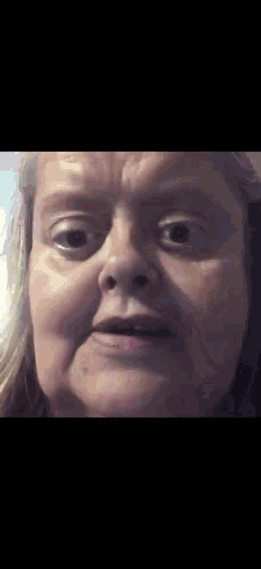 a close up of a woman 's face making a funny face