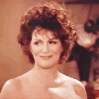 a naked woman with curly hair is smiling