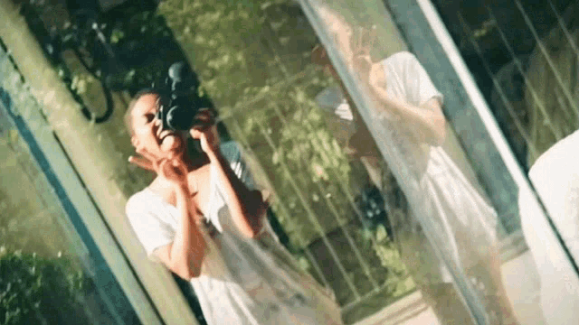 a woman is taking a picture of her reflection in a mirror .