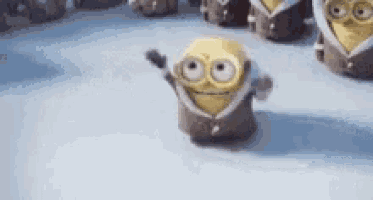 a group of minions are standing on a snowy surface .