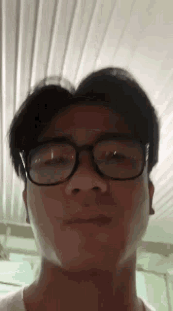 a close up of a man wearing glasses making a face .
