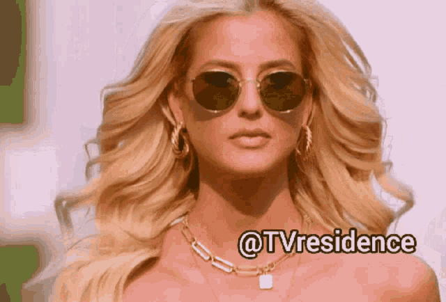 a woman wearing sunglasses and a necklace with the words @tvresidence written below her