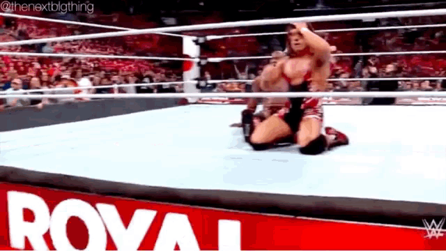 a wrestler is kneeling down in a wrestling ring with a royal sign in the background