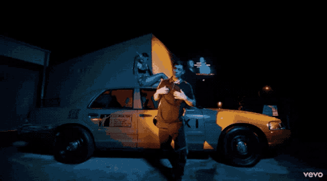a man stands in front of a taxi that says taxi