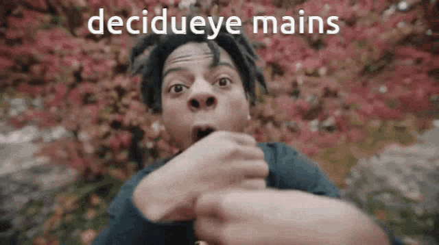 a man with dreadlocks is making a funny face with the words decideeye mains written above him .