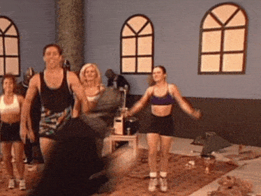 a group of people are doing exercises in a gym