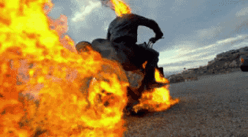 a man is riding a motorcycle with flames coming out of it .