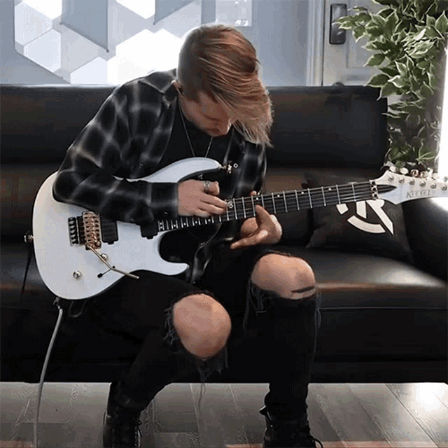 a man is playing a guitar with a sticker on the back that says ' a '