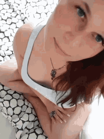a woman wearing a white tank top that says easy on the front