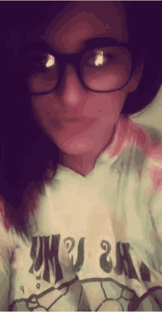 a woman wearing glasses and a tie dye shirt that says u.k.
