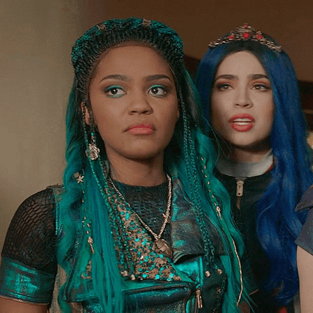 a woman with blue hair stands next to another woman with black hair
