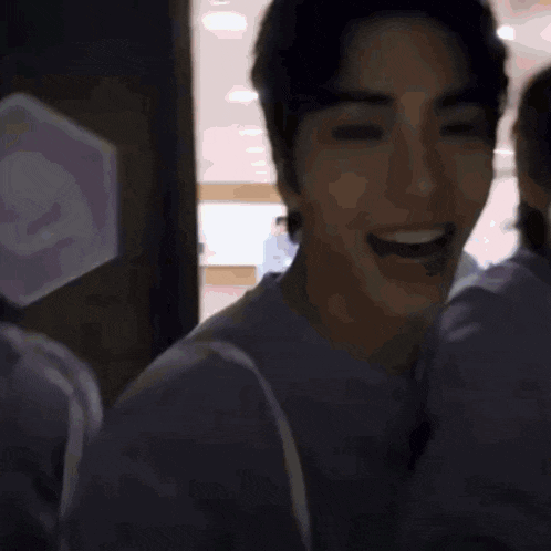 a man in a purple shirt is taking a selfie with another man