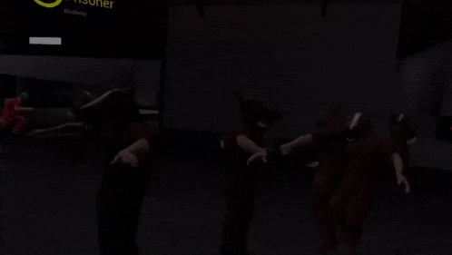 a group of people standing in a dark room with a sign that says ' exit ' on it