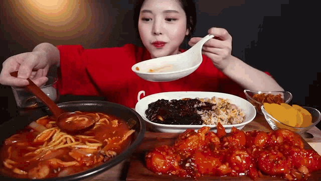 a woman is sitting at a table eating a variety of foods .