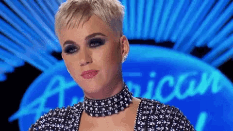 a woman wearing a choker and earrings is standing in front of a sign that says american idol .