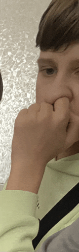 a close up of a person 's face with their hand on their nose