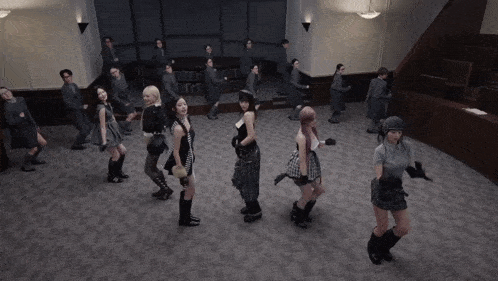 a group of women are dancing in a room with people standing around them