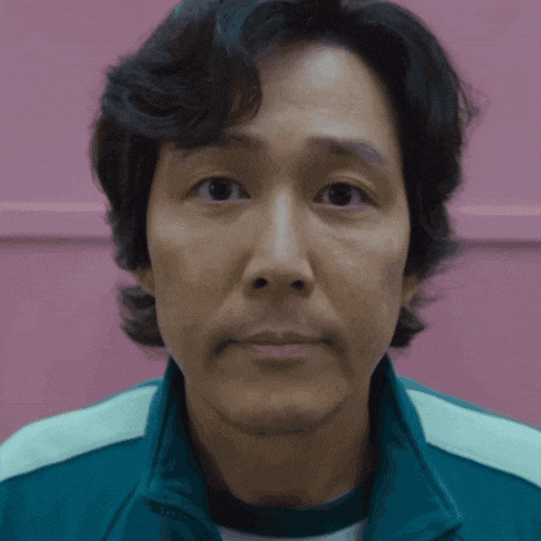 a close up of a man 's face against a pink background