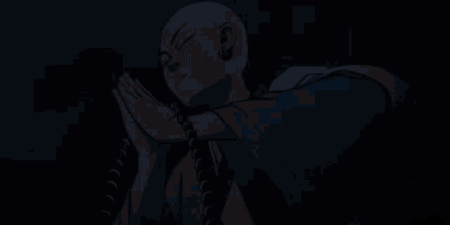 a bald man in a kimono is holding a string of beads around his neck