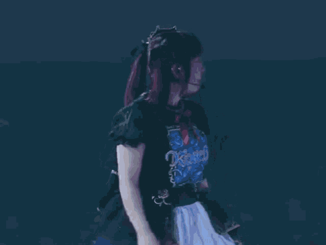 a woman with red hair and a blue shirt is standing on a stage .