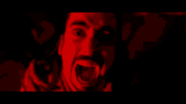 a man with a beard is screaming in the dark