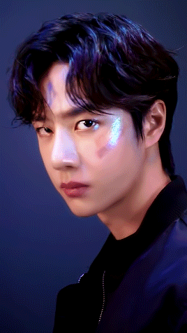 a close up of a young man 's face with a blue background